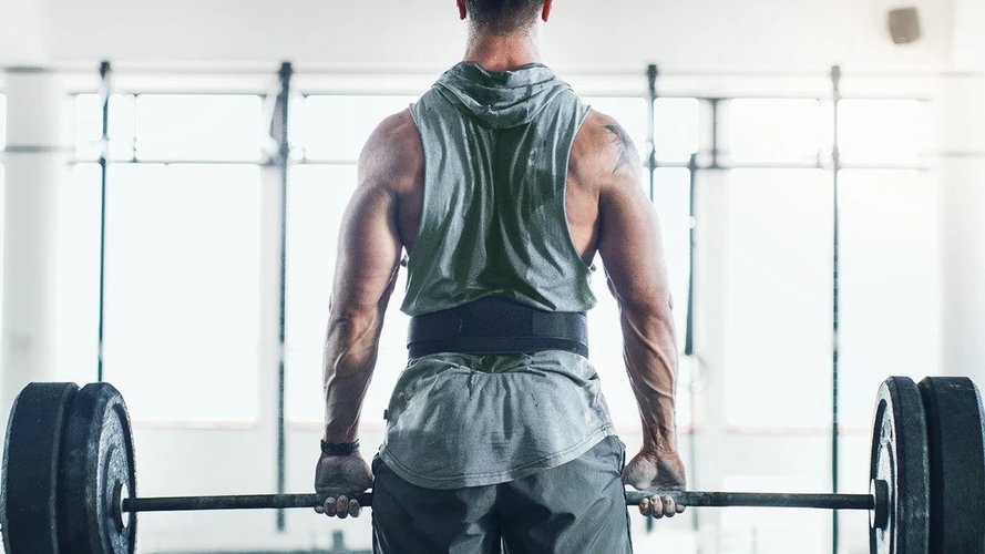 A man doing exercise wearing a weight lifting belt