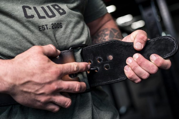 A man tightening a weightlifting belt