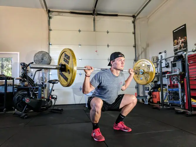 Man squatting with barbell on back
