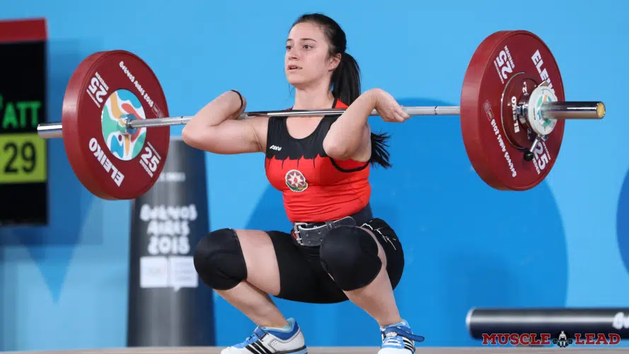 A female weight lifter performing lifts wearing a belt