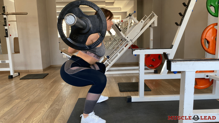 A female lifter performing the squat